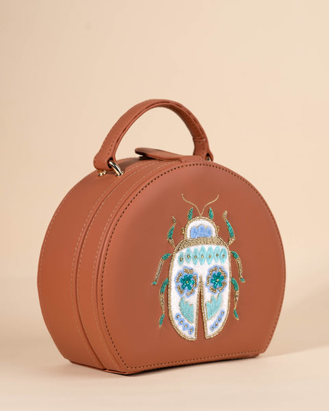 catching tan sling bag with hand embroidery, sequins, and detailed bug design