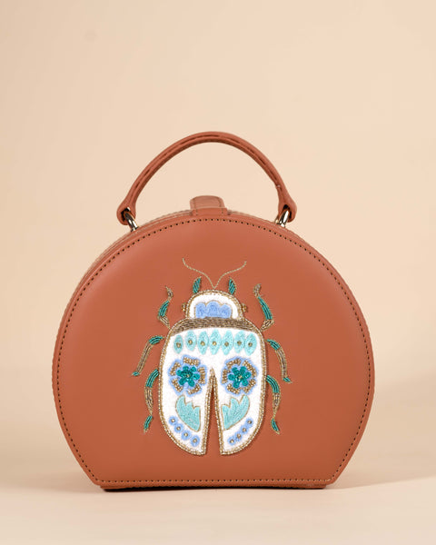 Stylish brown leather sling bag with hand-embroidered bug design and colorful threadwork