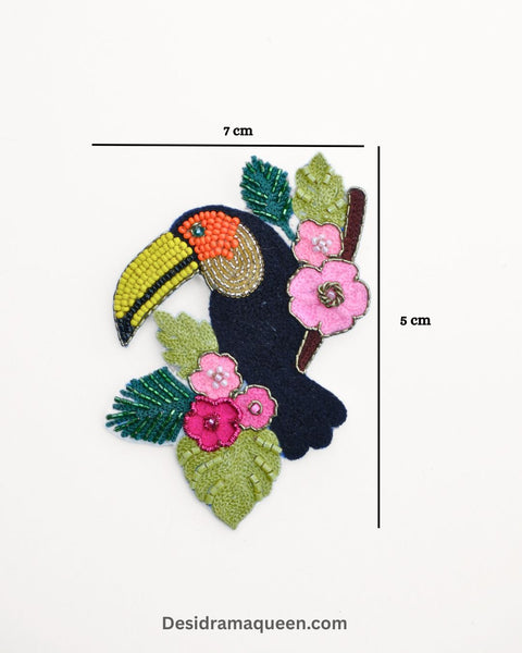 Black toucan brooch with yellow beak and pink flower details