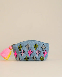Small pouch with cactus patterns and a pink tassel on a beige background