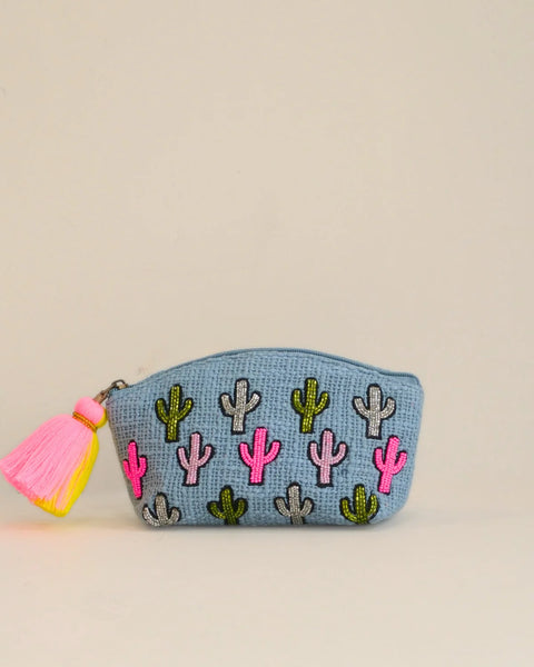 Small pouch with cactus patterns and a pink tassel on a beige background