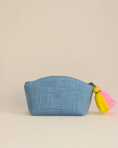 Blue pouch with a yellow and pink tassel on a beige background