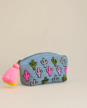 Small pouch with cactus patterns and a pink tassel on a beige background