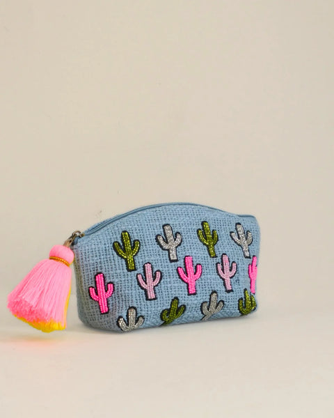 Small pouch with cactus patterns and a pink tassel on a beige background