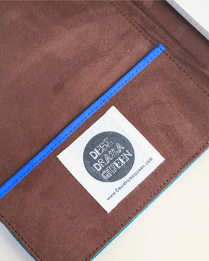 Brown leather product with a label featuring 'Desi Drama Queen' on a white background