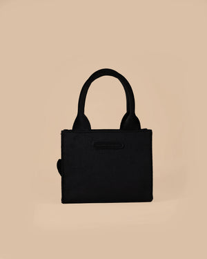 Black handbag on a beige background