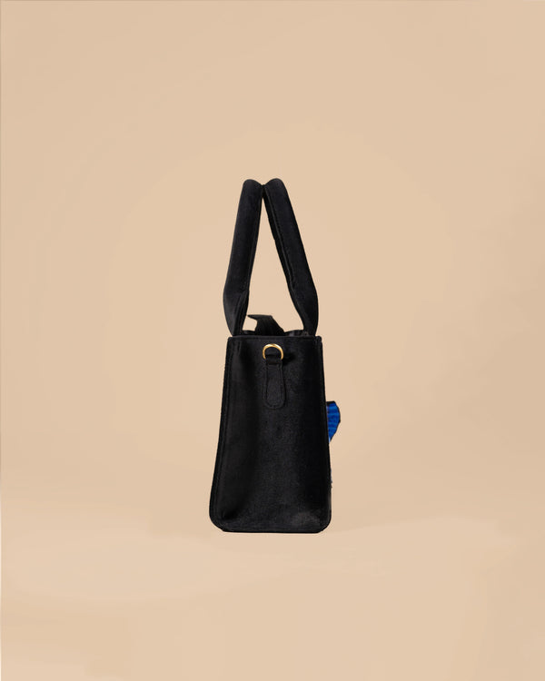 Black handbag with a strap on a beige background