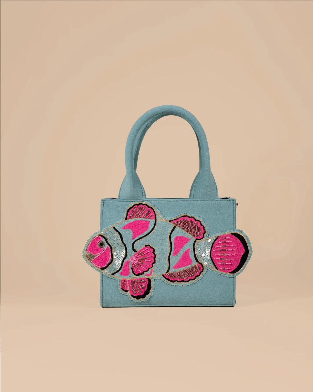 Blue handbag with pink fish designs on a beige background