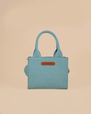 Light blue handbag with a brown label on a beige background