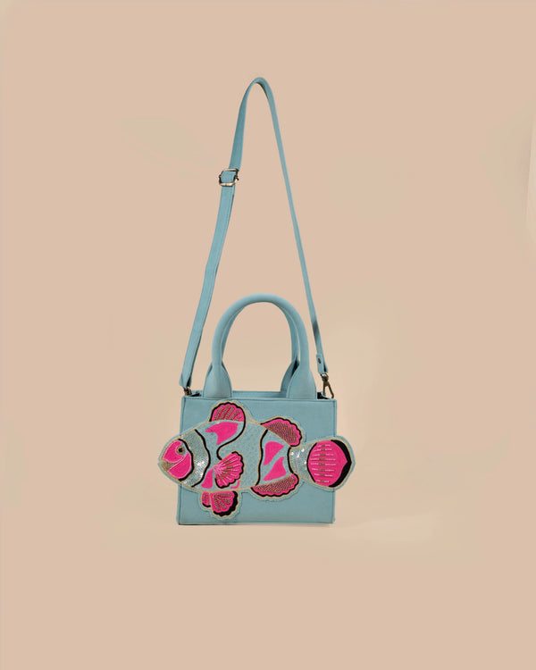 Light blue handbag with pink floral designs on a beige background