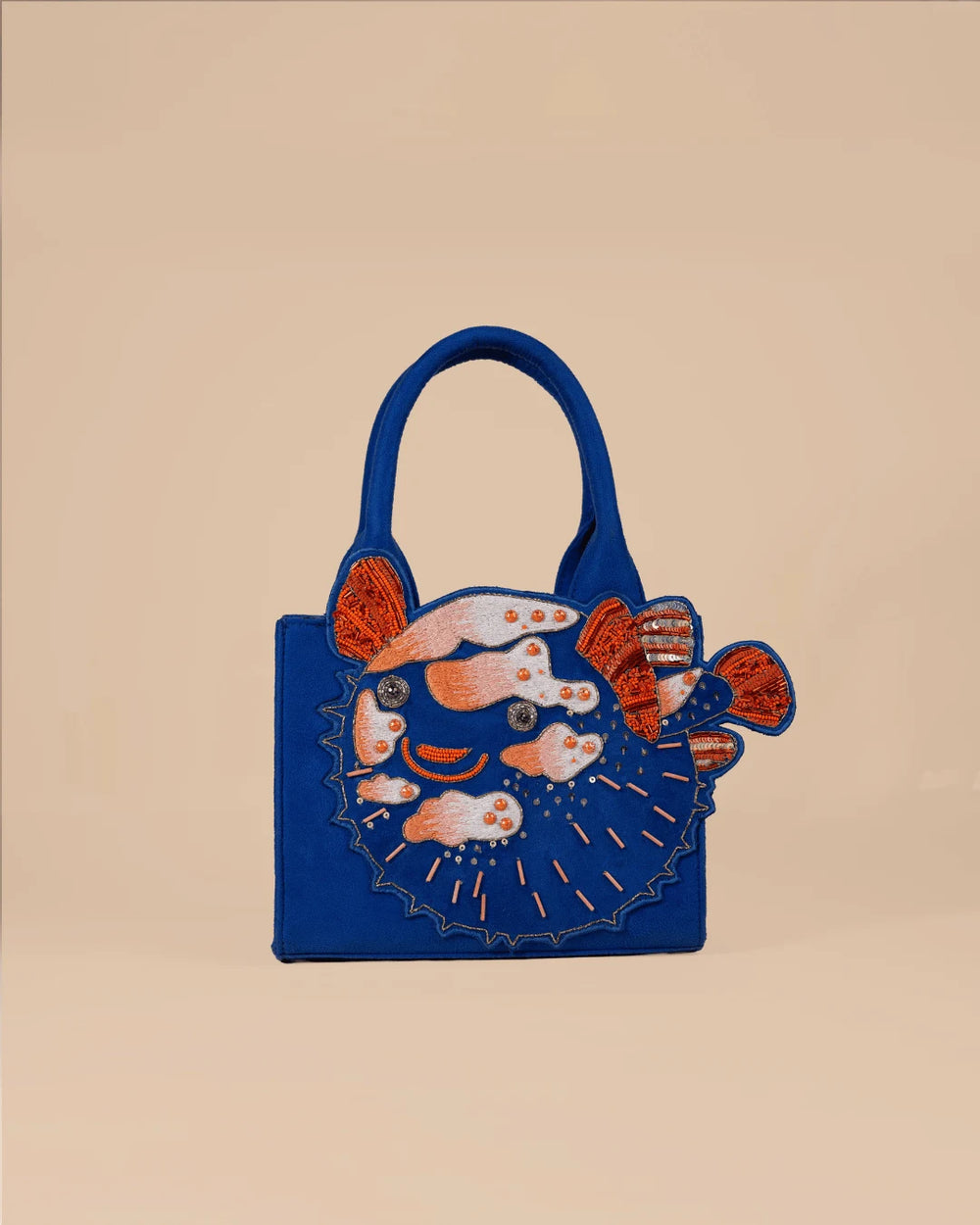 Blue handbag with fish design on a beige background