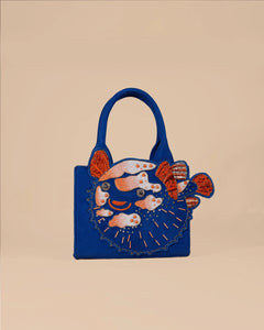 Blue handbag with fish design on a beige background