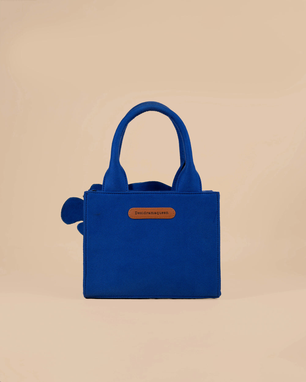 Blue handbag with fish design on a beige background