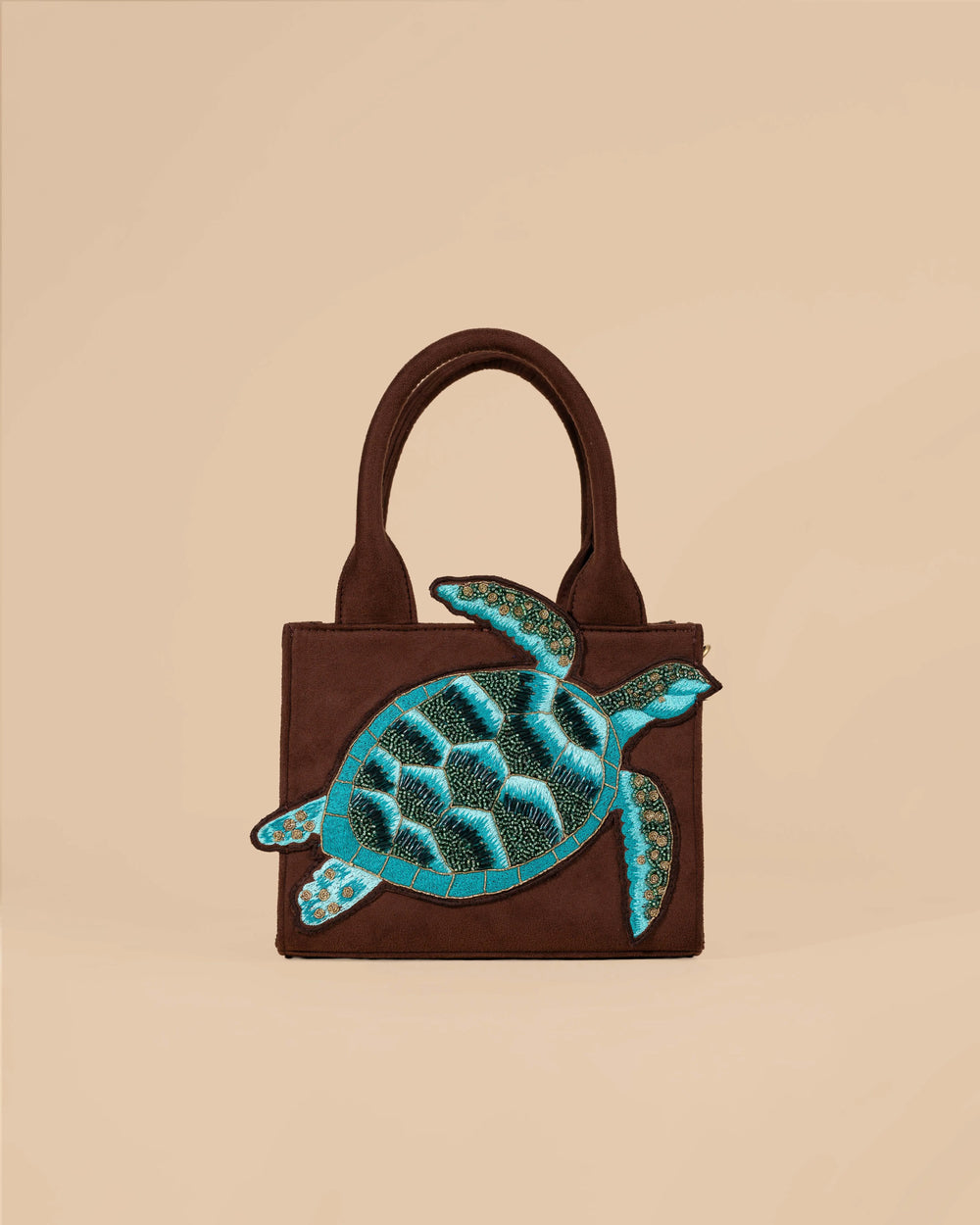 Brown handbag with a green turtle design on a beige background