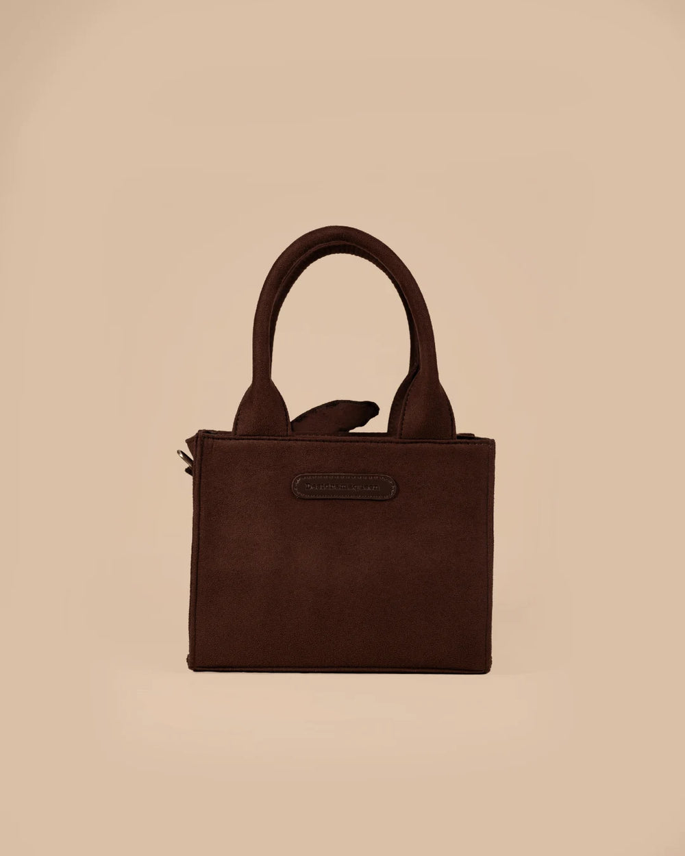 Brown handbag with a green turtle design on a beige background